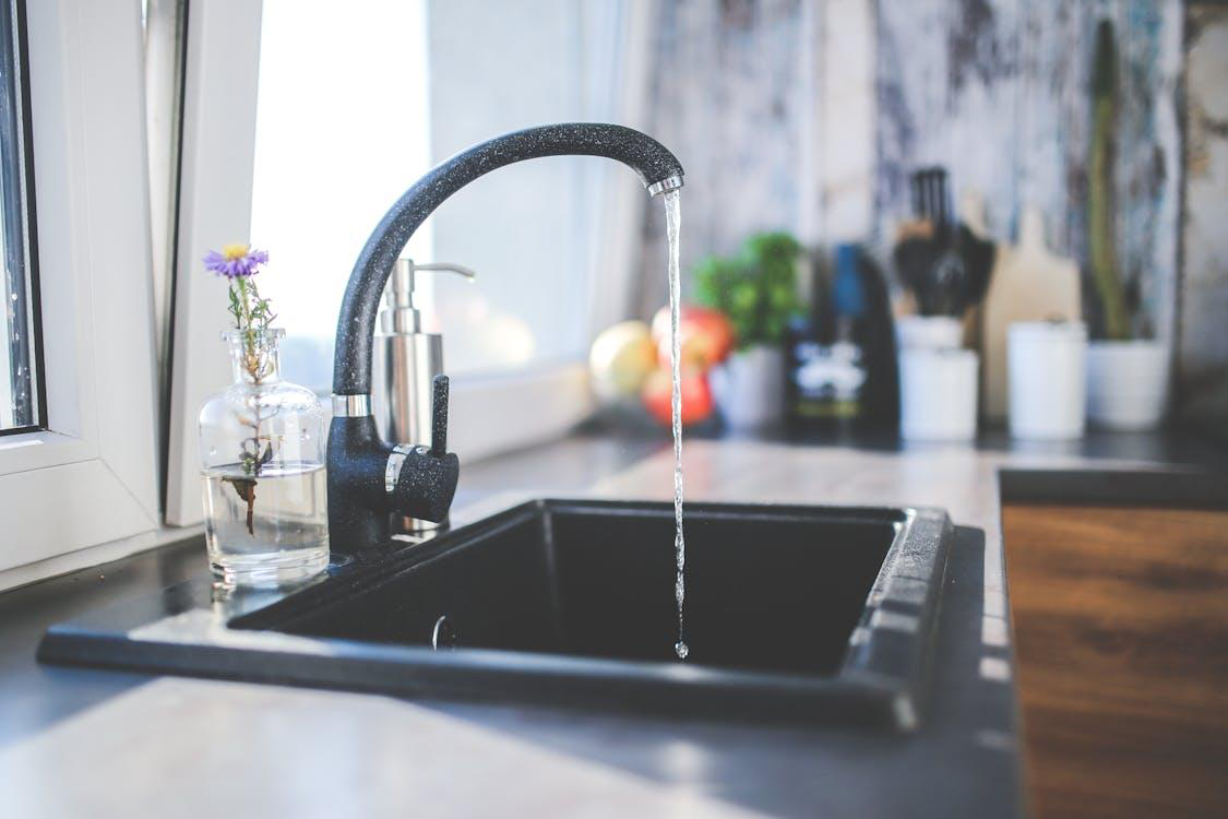 Water flowing from a tap into a sink, symbolizing how pressure valve repair ensures smooth water flow in your home’s plumbing system.