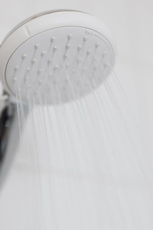 A close-up of a white shower head with a clean design, showcasing how consistent water pressure affects everyday bathroom use.